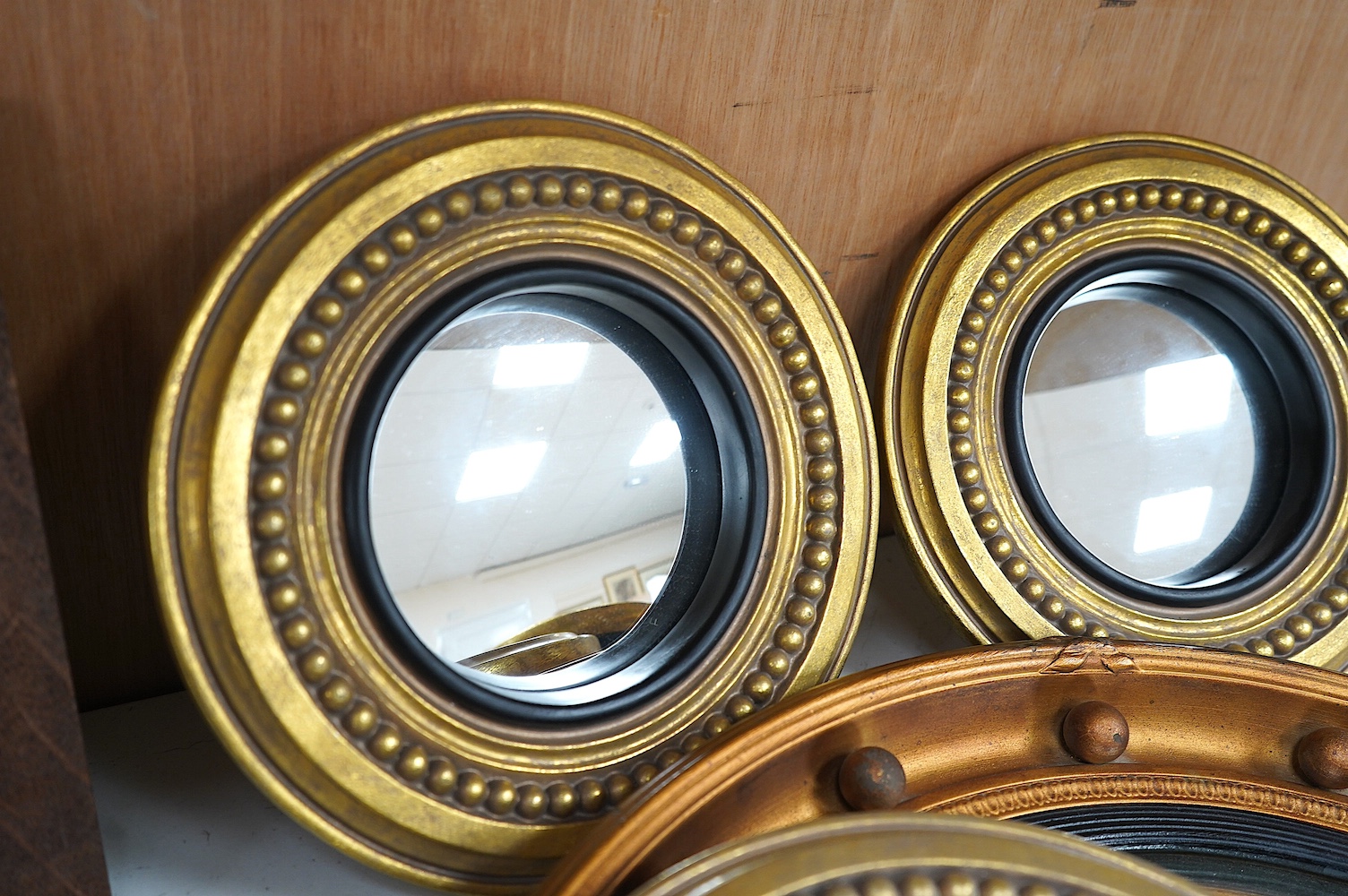 A convex gilt painted wall mirror and four small similar mirrors, convex mirror 46cm diameter (5). Condition - convex mirror, gilt scratched in places, others good